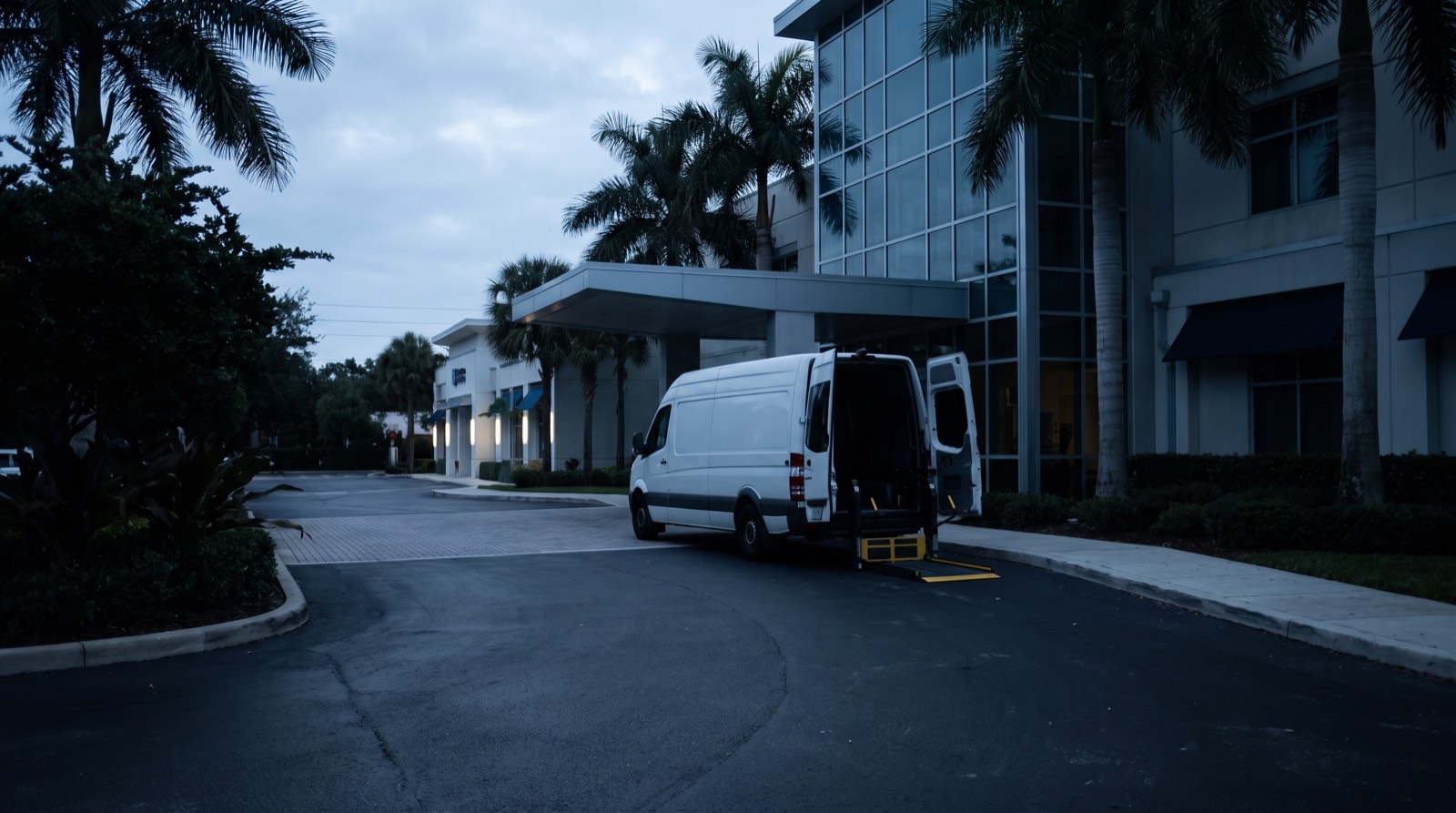Illustrative image, not the actual property. A white wheelchair-accessible transport van with its lift lowered outside a Florida medical center at dawn